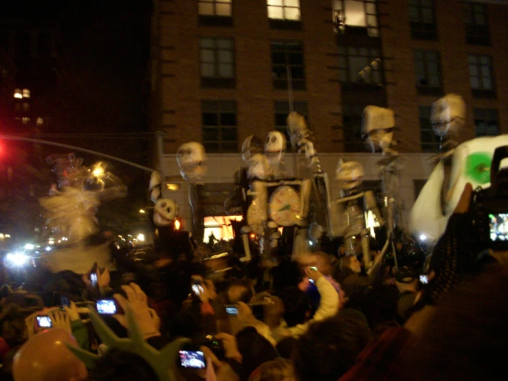 some skeleton like people in a parade with cell phones