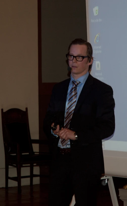 a man in a suite and tie speaking to an audience