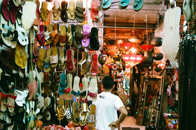 a man is looking at many pairs of shoes