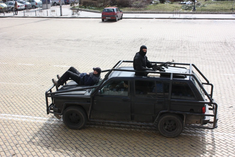 a group of men sitting on top of a truck in the street