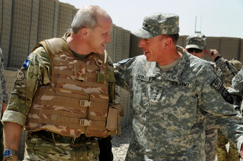 military men in camouflage uniforms smiling at each other