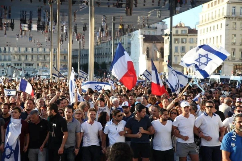 several people holding up israeli and british flags