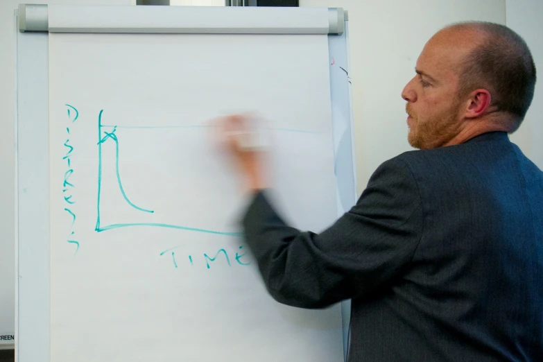 a man writing on a board while holding his hand in the air