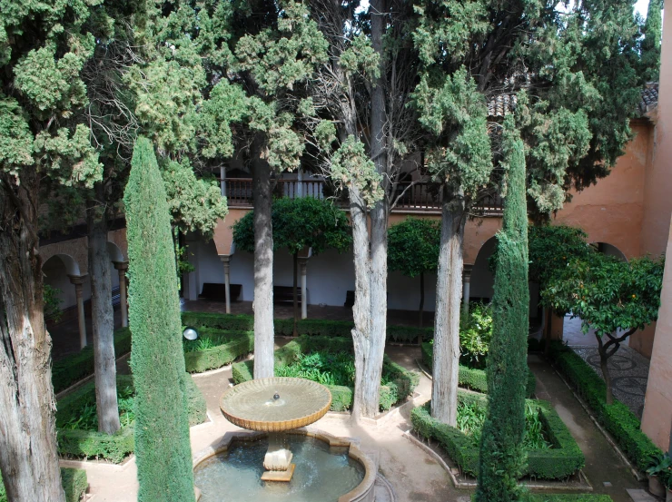 the garden and fountain in front of the building is surrounded by many trees