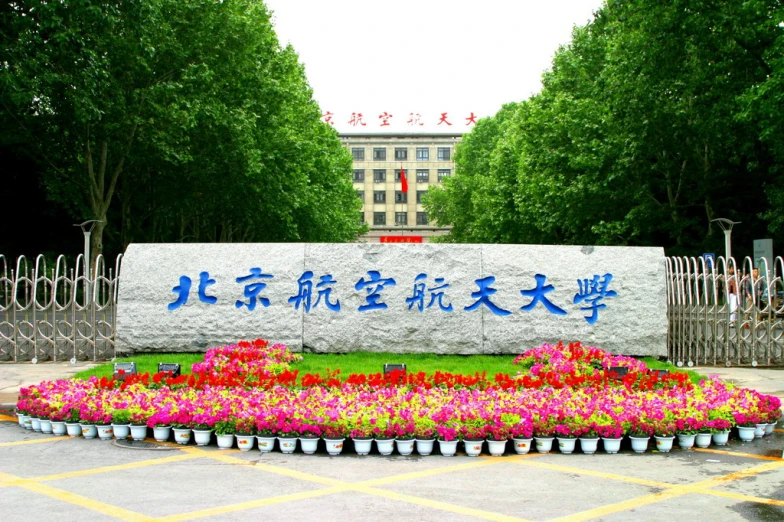 many potted plants near the sign and flowers are in front