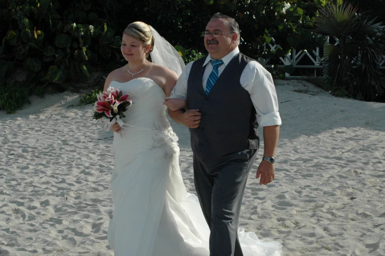 a man and woman walking on a beach next to each other