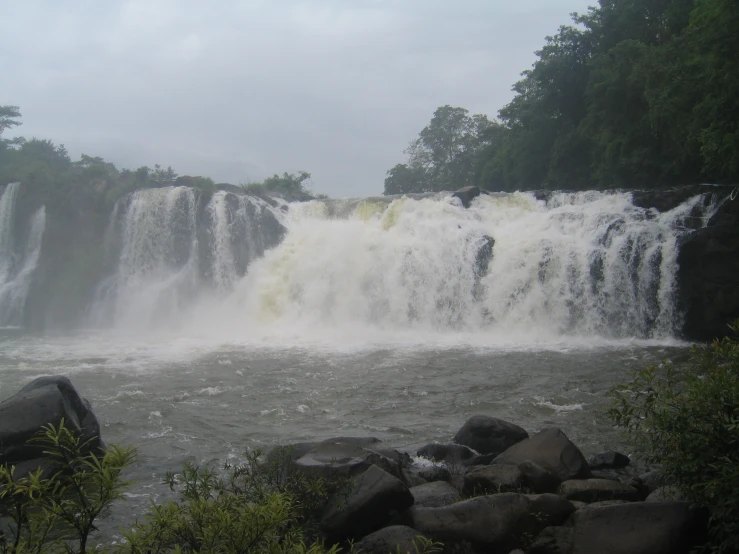 the water flows over large rocks into the water