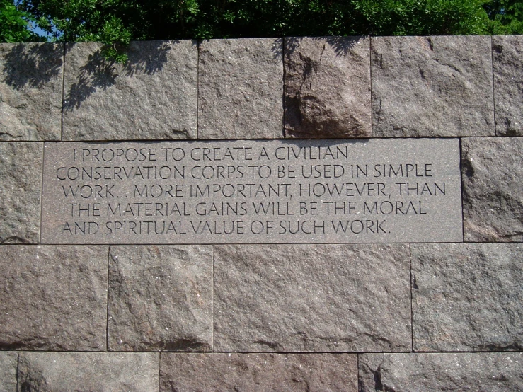 a memorial stone wall with words about propros to create a curtain