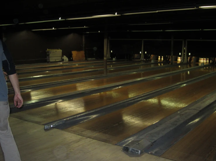 a man walks away from the empty seats of an empty bowling alley