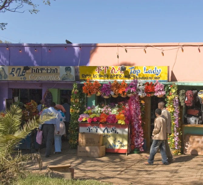 a man in a brown shirt standing outside a flower shop