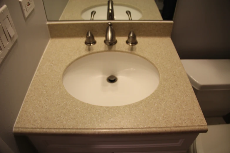 the bathroom sink is white with gold trim and under it's counter