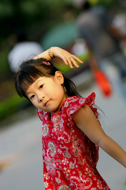 a young child holds her arm while she looks back at the camera