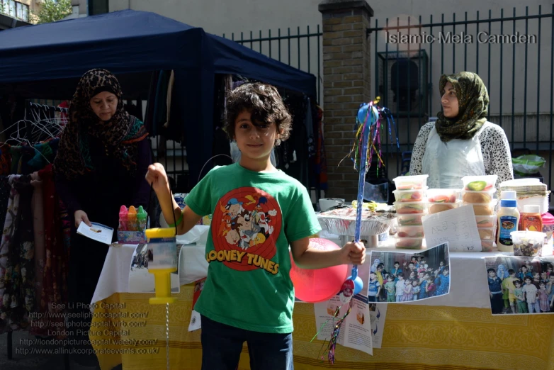  standing behind stand selling food at outdoor fair