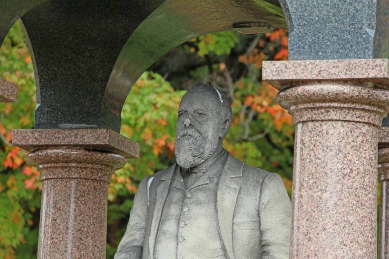 a statue is standing under some pillars