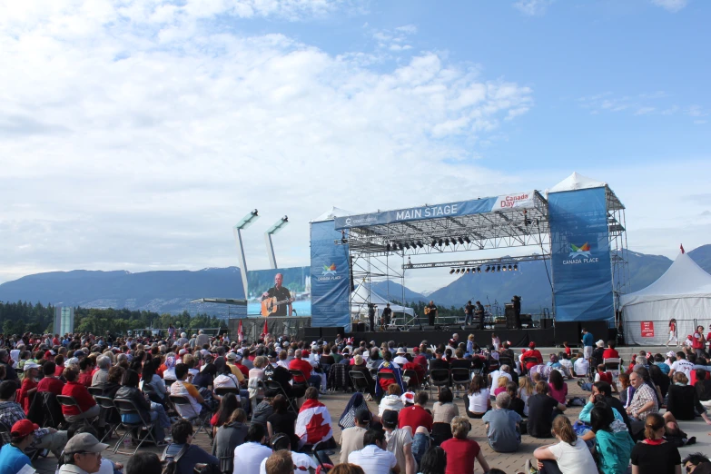 a crowd of people standing in front of a stage