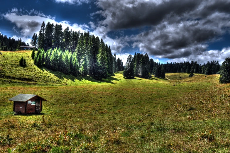 the small cabin is in a field under cloudy skies