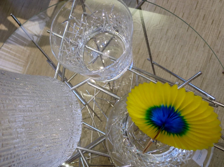 three glass vases with a yellow parasol with blue center and diamond base