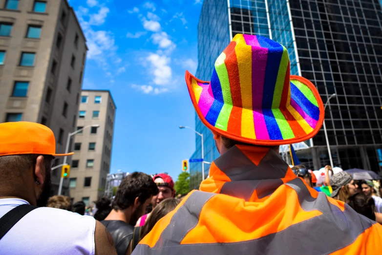 a person wearing a colorful hat and back to back on a busy street