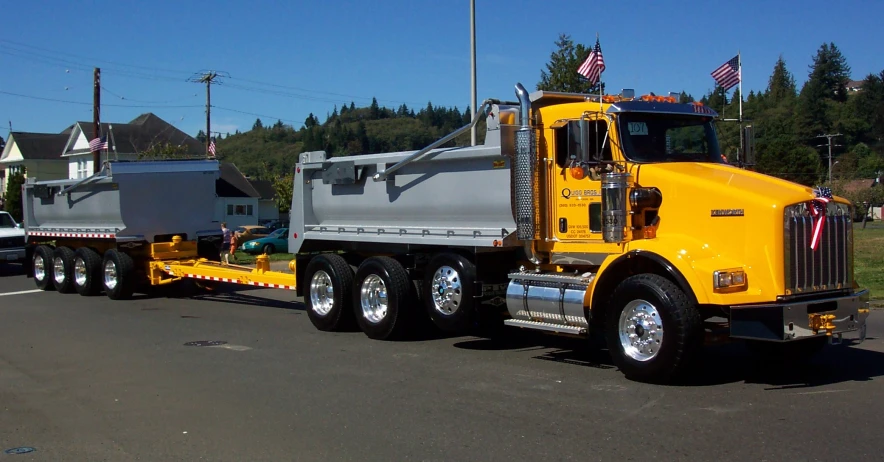 two yellow trucks are driving down the street