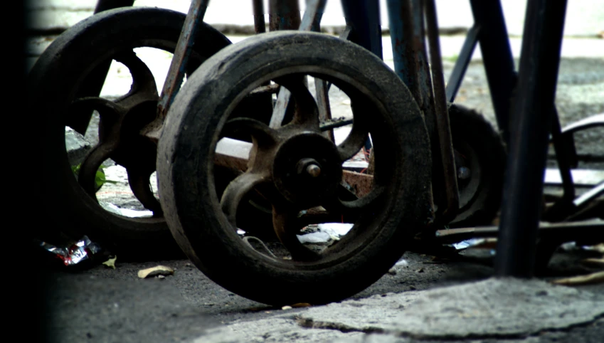 there is old cast iron wheels laying on the ground