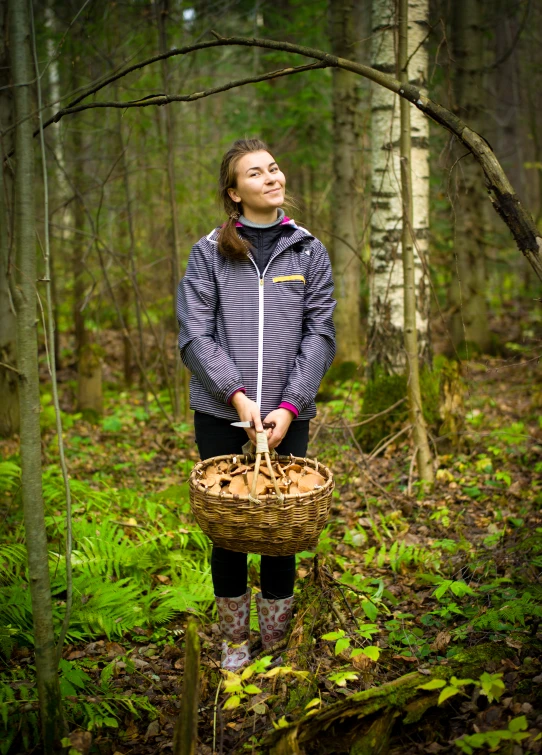 a young woman stands in the woods with an umbrella