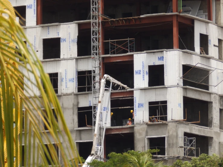 a large construction site with several workers on scaffolding