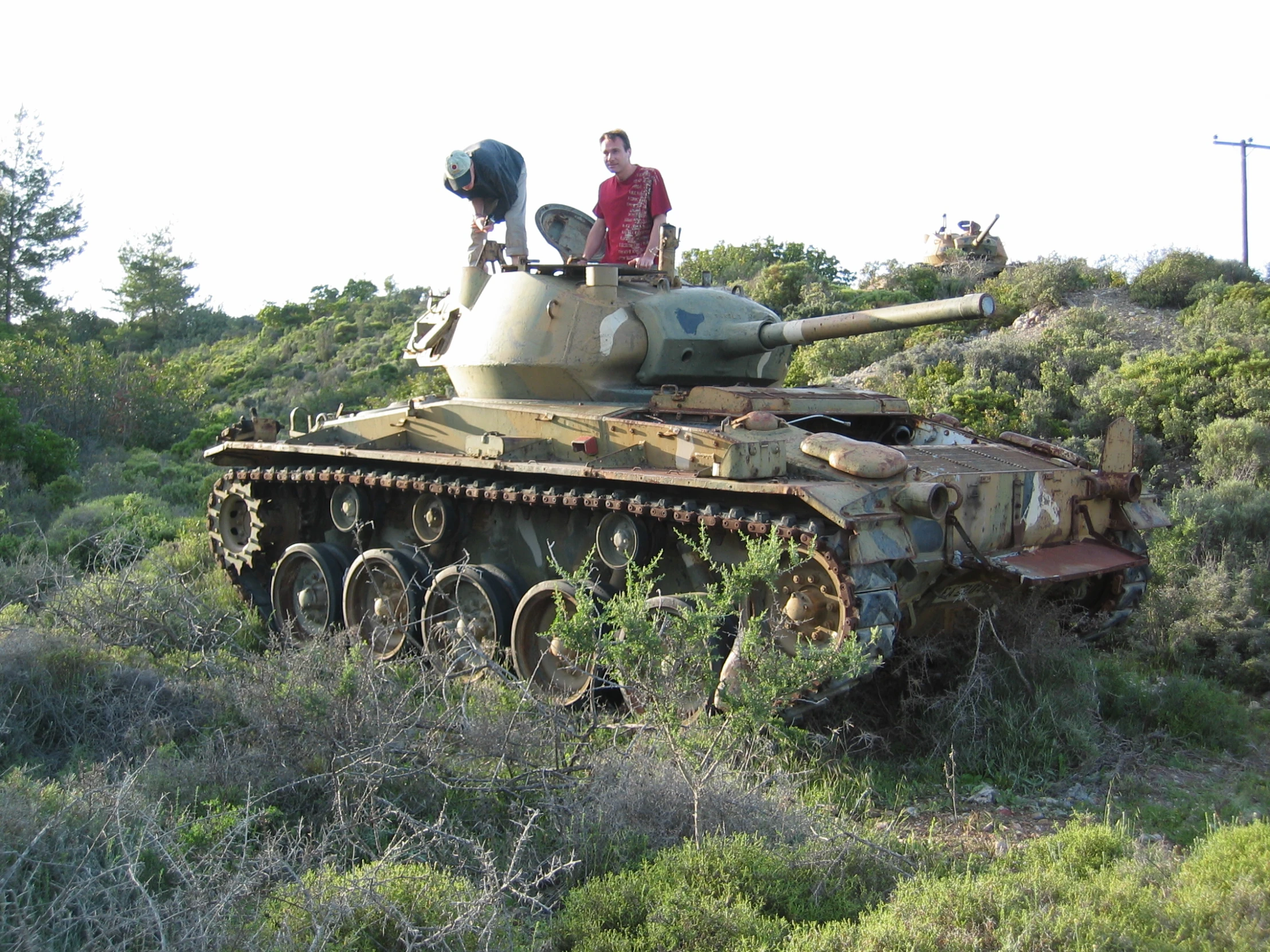 a man sitting on top of a tank in the forest