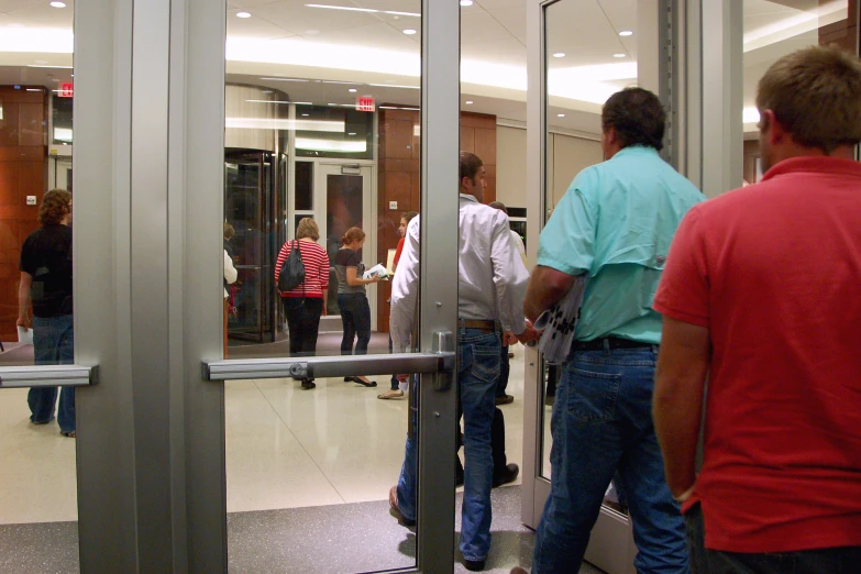 a group of people are outside the elevator