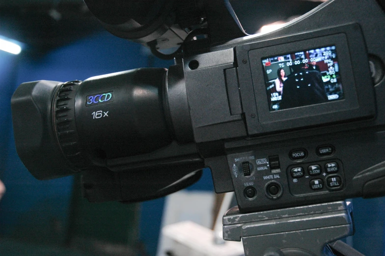 a video camera set up in front of blue curtains