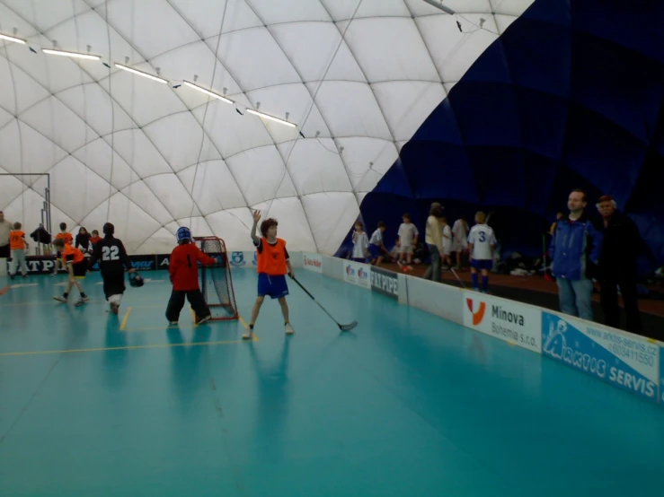 many people playing a game with paddles in a large indoor arena