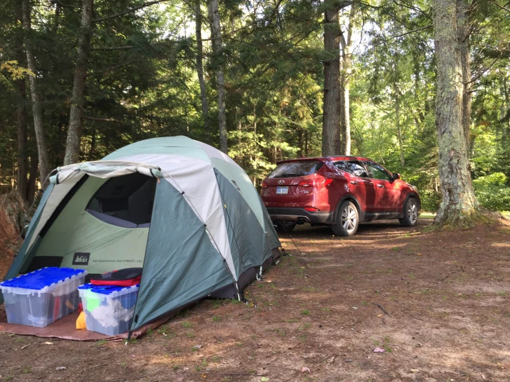 a car parked in the woods next to a tent