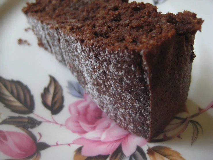 a slice of chocolate cake on a plate with flowers