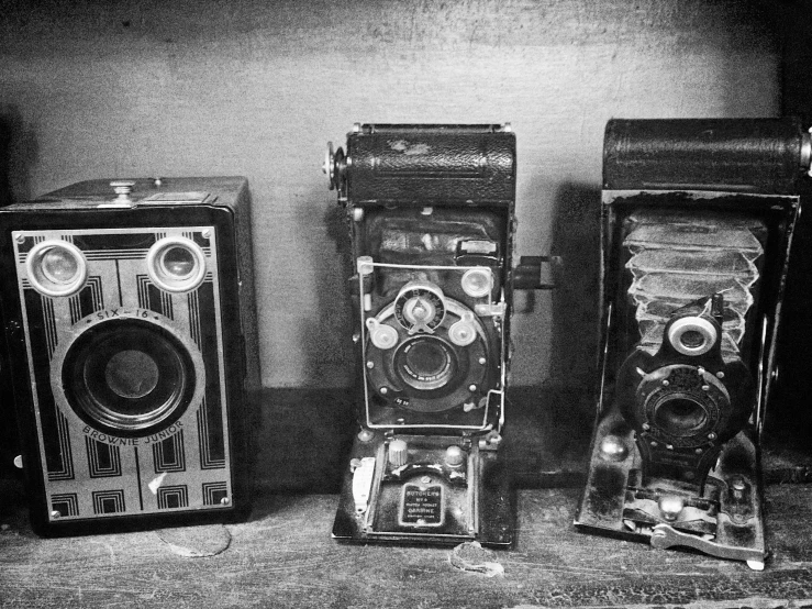 the old cameras are sitting beside each other on the table