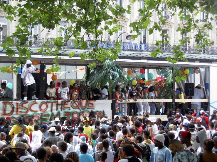 several people are standing in front of a building and some are holding signs