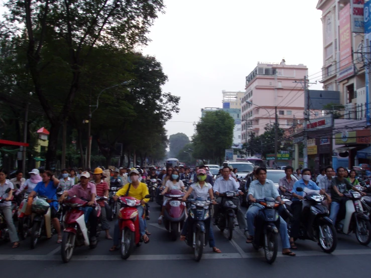 many people riding motorcycles down a busy city street