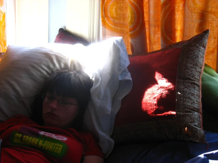 a person laying on a bed with pillows