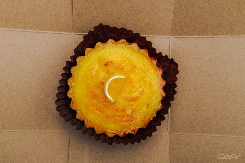 cupcake on brown paper with a white crescent sitting in top of it