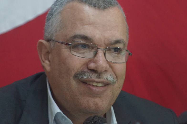 a man in a suit speaking into a microphone