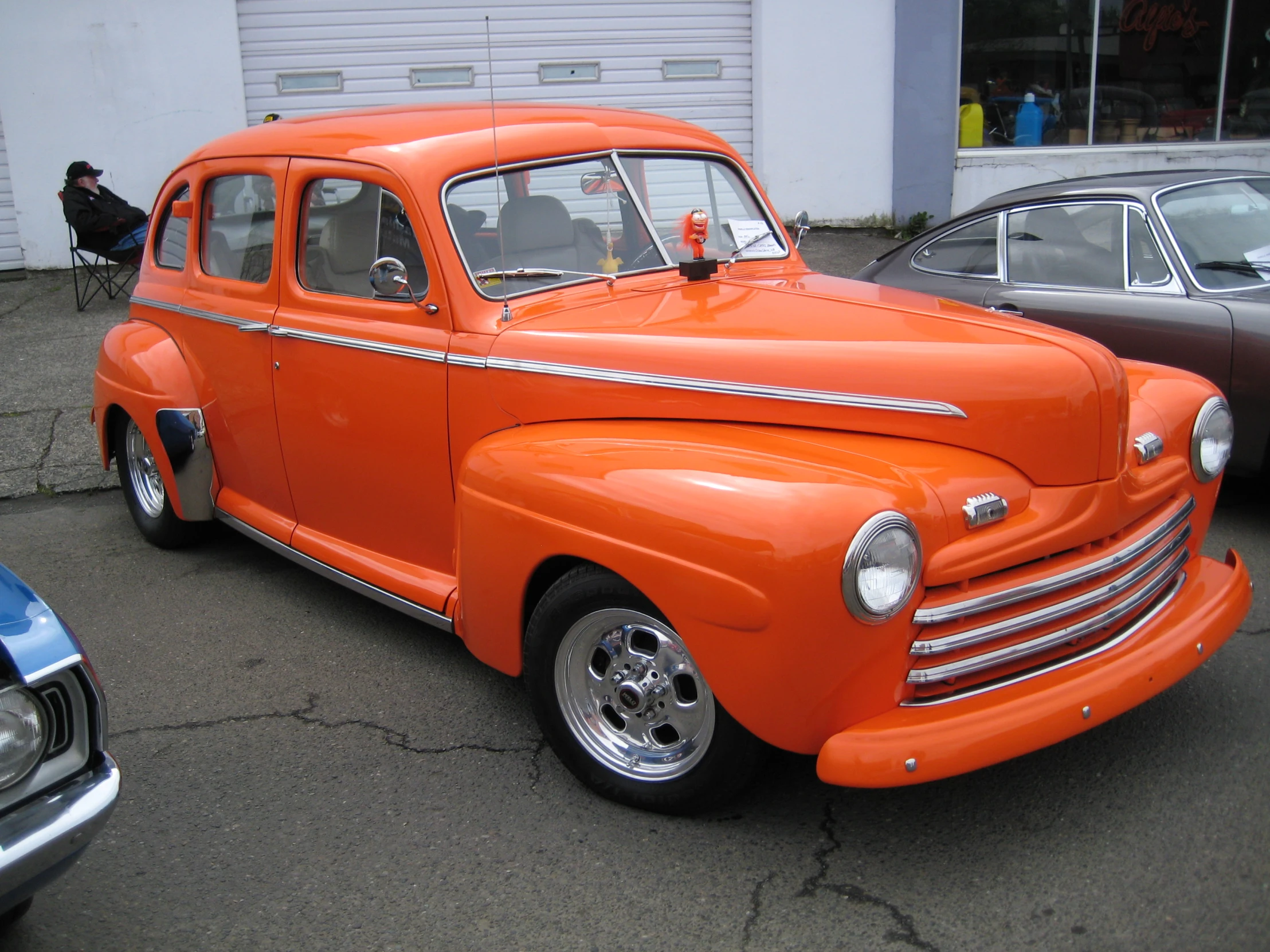 a orange old fashion pickup truck parked in a parking lot