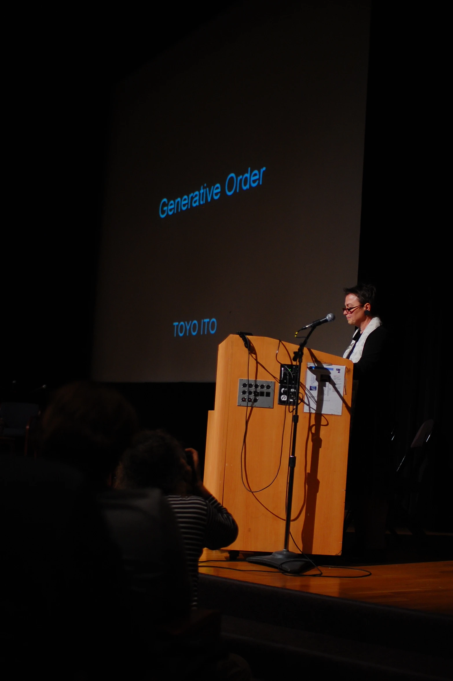 a man standing at a podium in front of a crowd