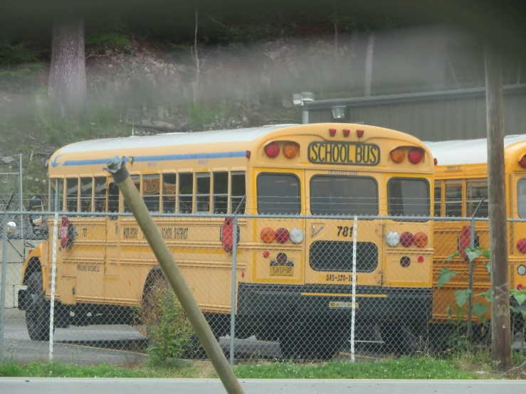 the back of a school bus behind a fence