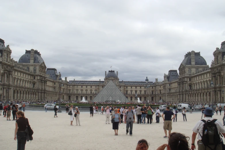 many people in a courtyard near some buildings