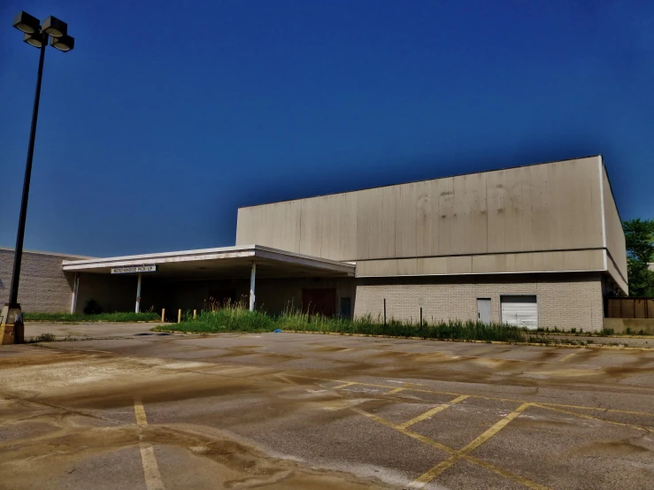 an empty parking lot that contains an abandoned building