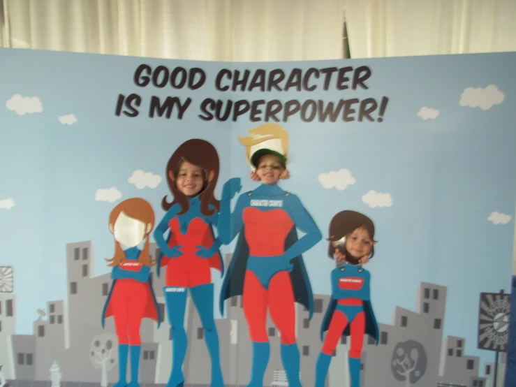 two children stand with their teacher in their superhero costume