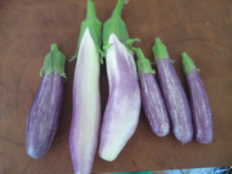 purple eggplant pieces are on a wood  board