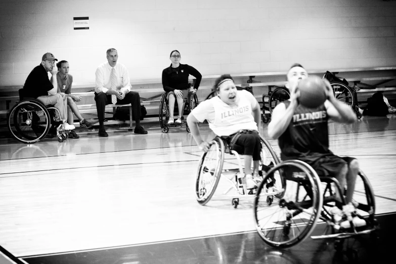 people in wheelchairs are playing basketball in an indoor court