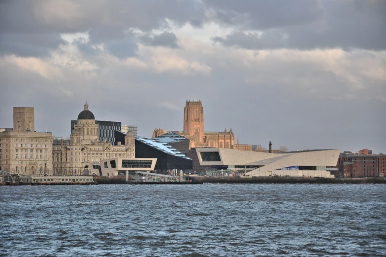 cityscape with a large body of water in the foreground and a building with steeple in the background