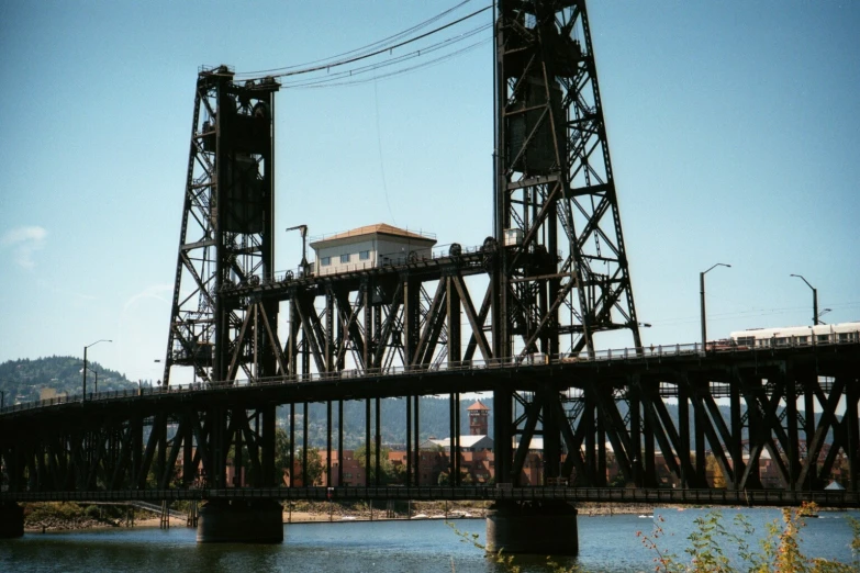 the train is on the bridge going over the water