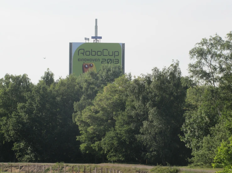 a billboard sign on top of a lush green field