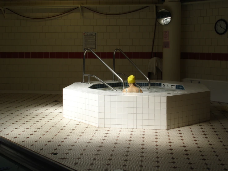 a person sitting in a pool with a yellow rubber duck on the side